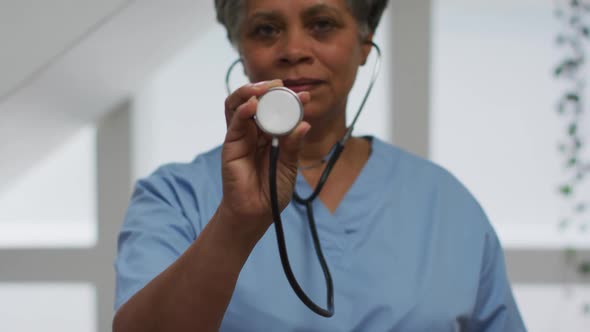 Portrait of senior african american female doctor holding stethoscope looking at camera