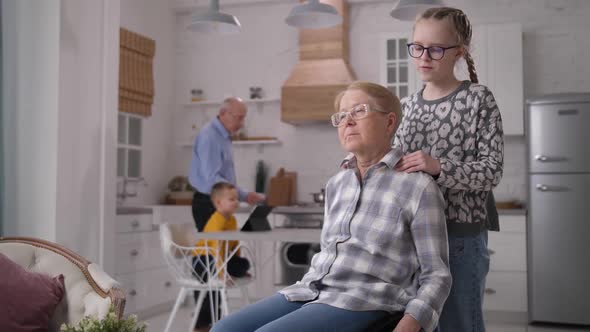 Caring Granddaughter Making Massage To Grandmother