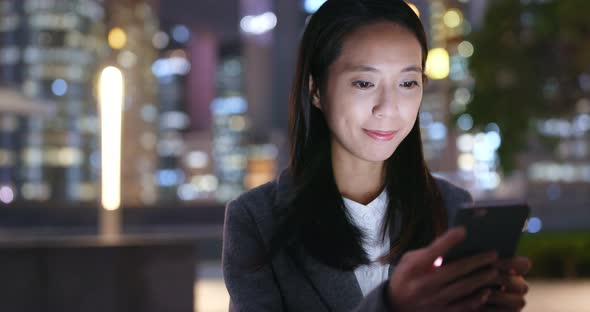 Businesswoman use of mobile phone at night