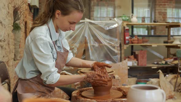 Woman Potter Working on Potter Wheel Making a Clay Pot