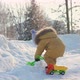 A kid of 15-23 months digs snow with a toy shovel. - VideoHive Item for Sale