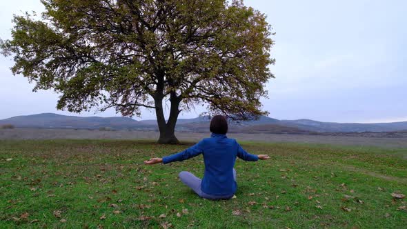 Back View of Unrecognizable Slender Young Woman in Lotus Position