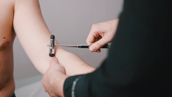 The Neurologist Checks the Reflex of the Patient's Hand