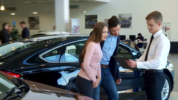 Couple Looks at the Contract at the Dealership