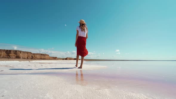 Camera Following Cheerful Woman in Red Skirt Walking By Salt White Beach and Enjoying Summer