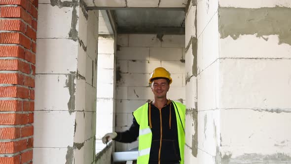 Construction worker at construction site measures the length of the window opening