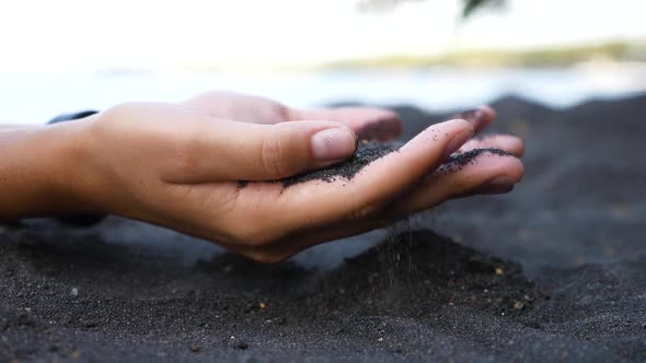 Hand Pours the Sand