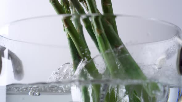 Camera follows cooking asparagus in boiling water. Slow Motion. alt