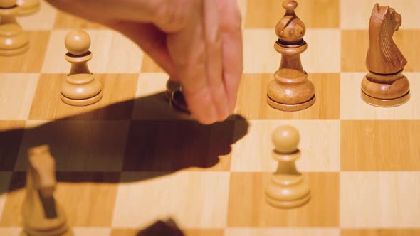 The hands of two chess players move the pieces alternately, taking some chess pieces off the chess b