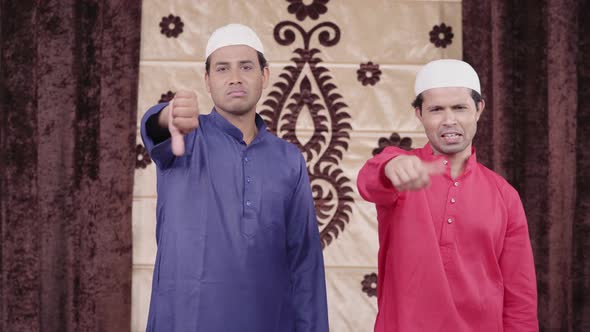 Two Muslim men showing thumbs down