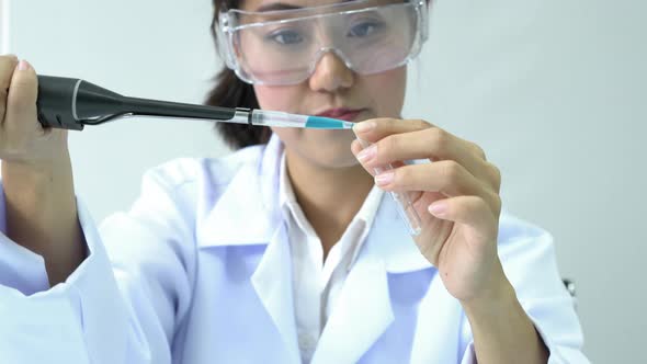 Scientist experimenting with chemicals compound and absorb liquid the test tube