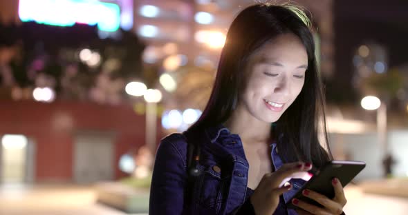 Woman use of mobile phone in city at night