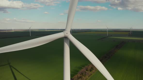 Rotating Blade of Windmachine on Green Field in Summer