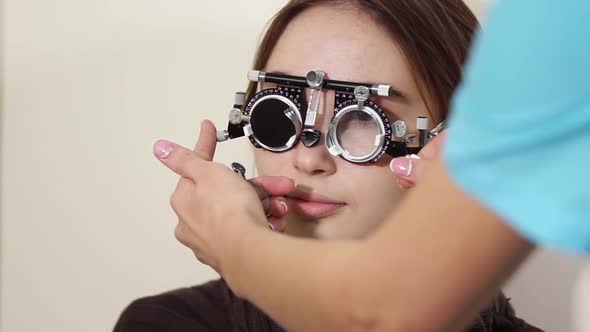 Ophthalmologist Is Trying on Lenses in a Trial Frame on Face of Woman
