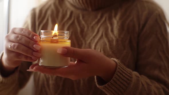 Closeup Cropped Shot of Unrecognizable Young Woman Blowing Out Handmade Candle Holding Near Chest