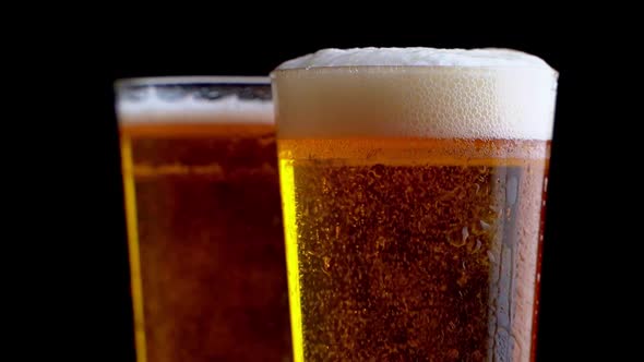 Two Glasses Full of Beer on Table with Black Background