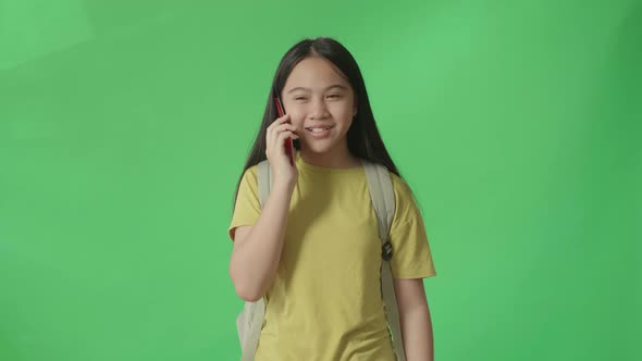 Asian Girl Student Talking On Mobile Phone And Walking To School On Green Screen Chroma Key