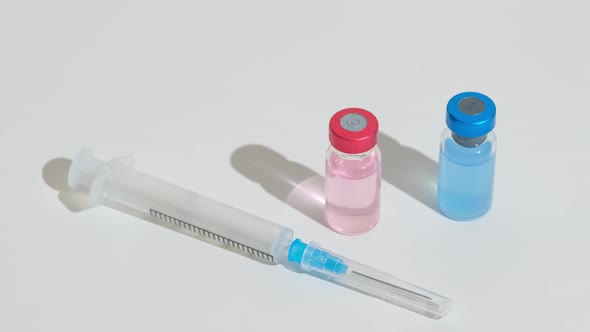 Unspecified Two Vaccine Vials and Syringe on the Table