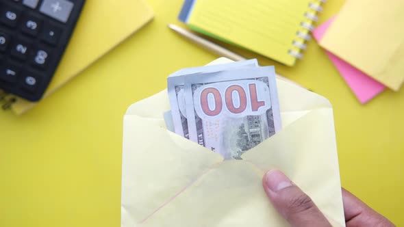 Person Hand Putting Cash in a Envelope