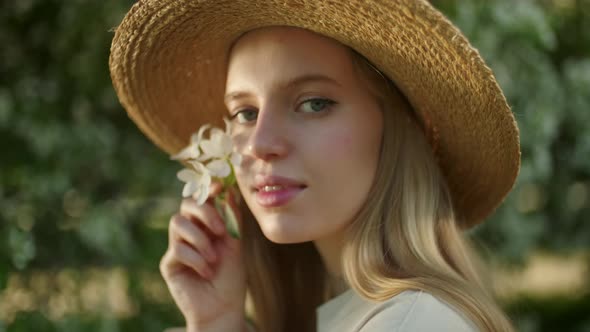 Portrait of Young Beautiful Blonde Woman in the Flowered Garden in Spring Time