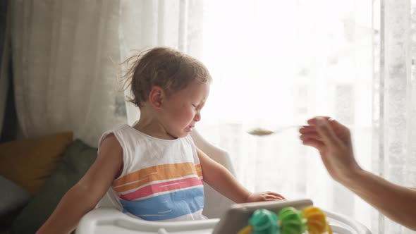 Little Blond Boy Does Not Want to Eat a Meal That Gives Him a Parent and Cry