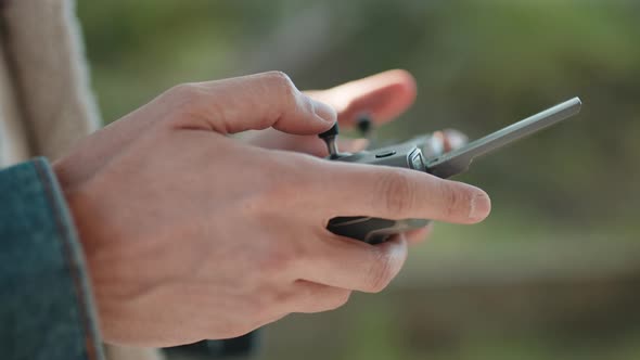 Hand of a Drone Operator Man While Pilot a Quadcopter Remote Controller