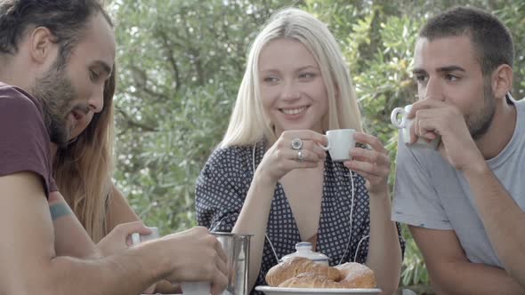 Group of Four Happy Men and Women Friends Smile Laugh and Drink Coffee During Italian Breakfast in