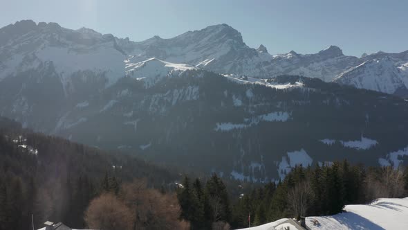 Aerial view of beautiful valley, drone pulling back and revealing small cabins in snow covered lands