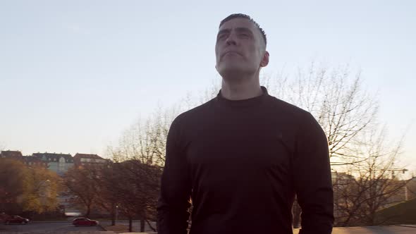 Young and fit man having evening workout outdoor. Urban sunset.