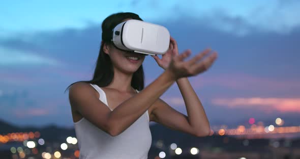 Woman watching on VR device in the evening 