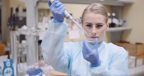 Scientist Using Pipette During Experiment at Laboratory