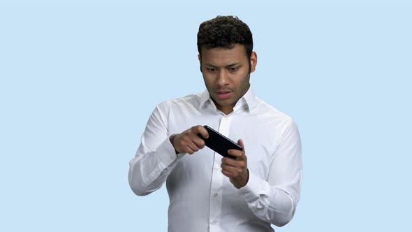 Expressive Businessman Playing Game on Mobile Phone