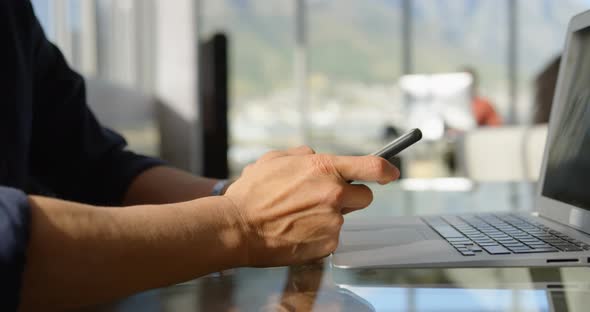 Asian business male executive using mobile phone at desk in office 4k