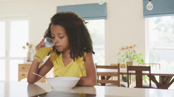 Front view of African american girl drinking juice in the morning