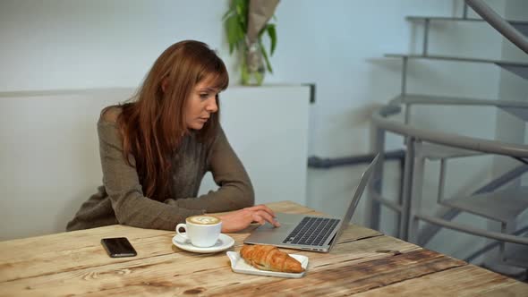 Woman Driking Coffee and Working in Coffeeshop