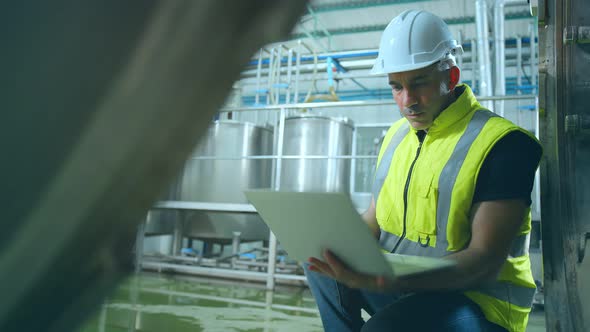 caucasian male senior engineering wearing safty uniform hand use laptop quailty control