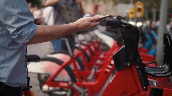 Tourist Man Take Electric Kick Scooter or Bike Bicycle in Sharing Parking Lot Tourist Phone