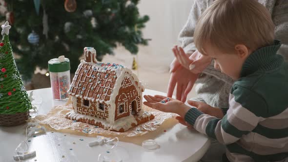 Little Boy with Mother Decorating Christmas Gingerbread House Together Family Activities and