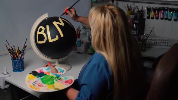 Overweight Woman Painting BLM Sign on the Black Globe