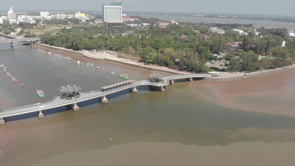 Aerial: Can Tho city skyline bridges over Mekong River, pedestrian walkaway waterfront skyscraper, M