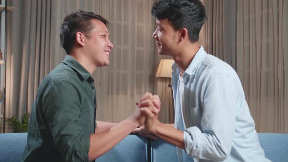 Young Asian Adult Gay Couple Spend Time At Home. Two Happy Men In Love. Gently Hold Hands