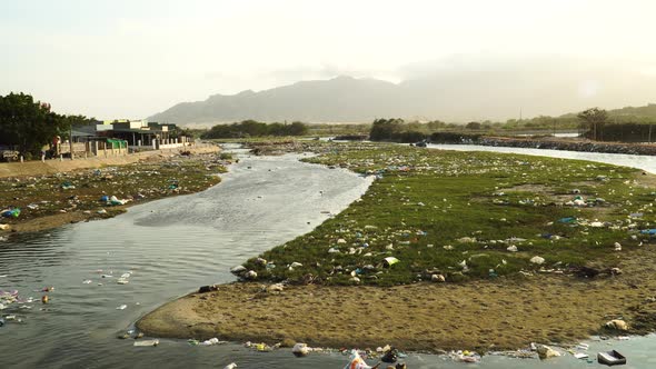 Large scale pollution of river with plastics and other human trash; static