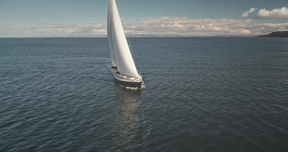 Aerial of Yacht Under Sails. Sailboat Reflect at Open Sea. Racing Yacht Seascape. Luxury Sail Boat