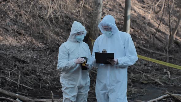 Forensic specialists working in the forest. Crime scene and police concept.