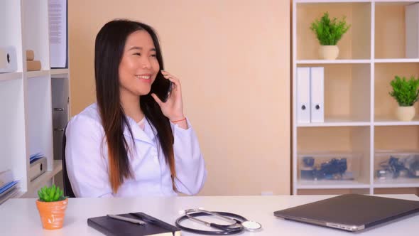 Physician Speaking By Mobile in Office