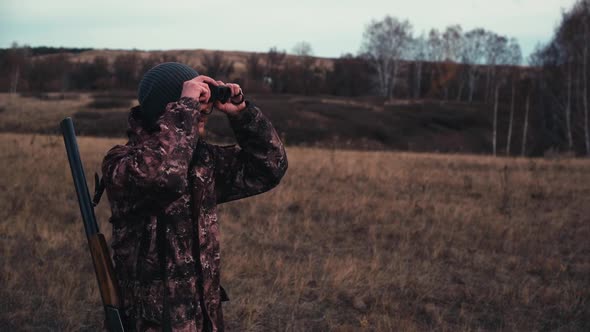 The Hunter is Looking Into the Binoculars