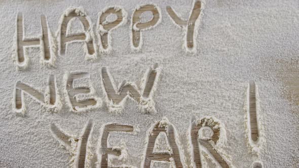 The word happy new year written on sprinkled flour 4k