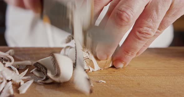 Close up of a chef knife slicing a portobello mushroom