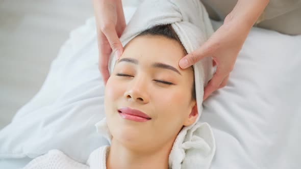 Asian young woman feel happy and relax during facial and head massage.