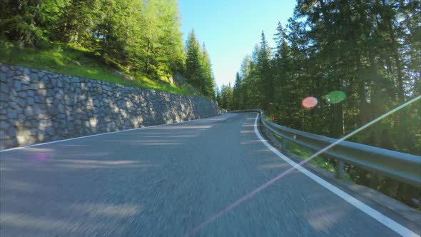 Driving on the Alpine road through forest